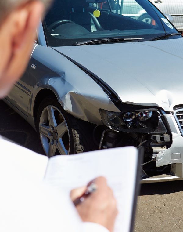 Loss Adjuster Inspecting Car Involved In Accident