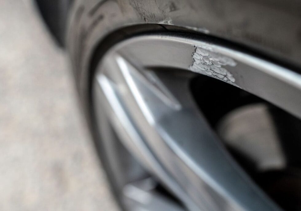 Close-up of a scratched and bent alloy wheel needing repair